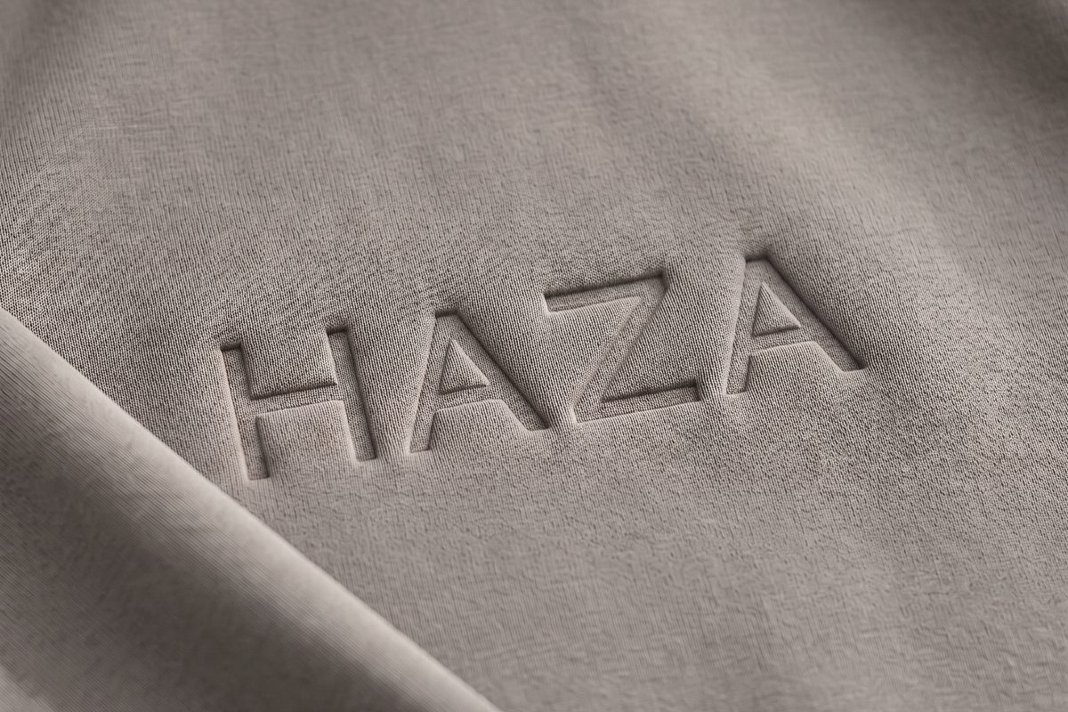 Logo HAZA di-press ke kain hoodie warna Taupe, tampak dekat